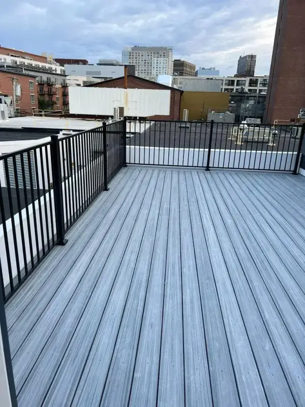 Backyard composite deck with white posts and black balusters in Holliston, MA