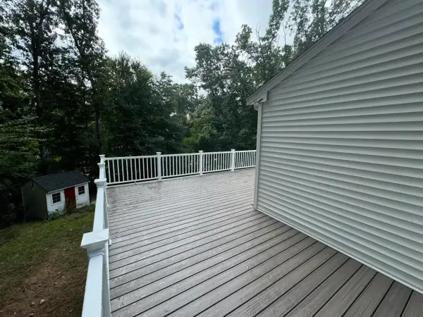 Large composite deck with white posts and dark railings in Bellingham, MA