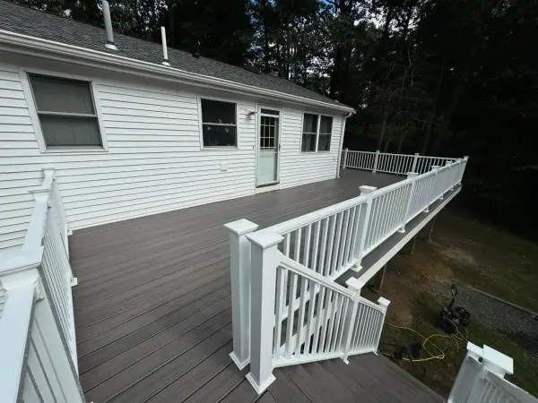 Spacious wrap-around composite deck with white vinyl railings in Bellingham, MA