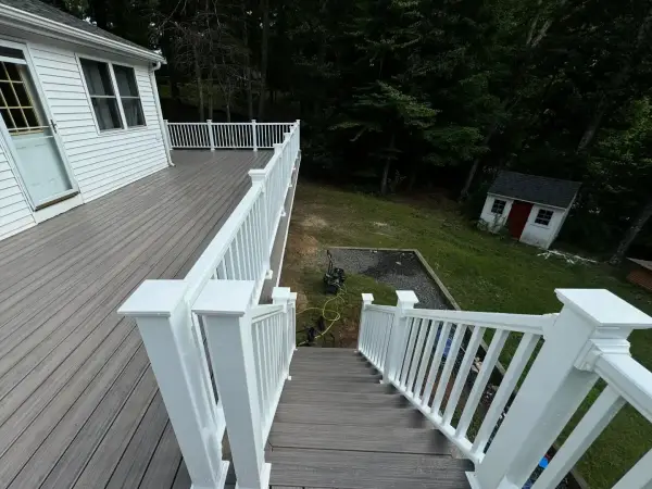 Multi-tiered composite deck showcasing glass railing integration built in Dover, MA